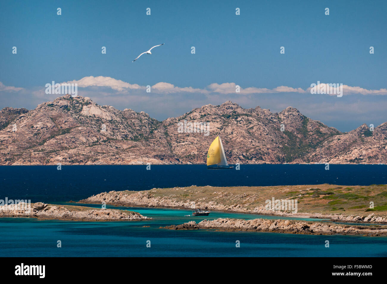 Caprera island,Sardinia, Italy, 5/2015. Yellow sail luxury yacht navigate along the coast of La Maddalena archipelago. Stock Photo