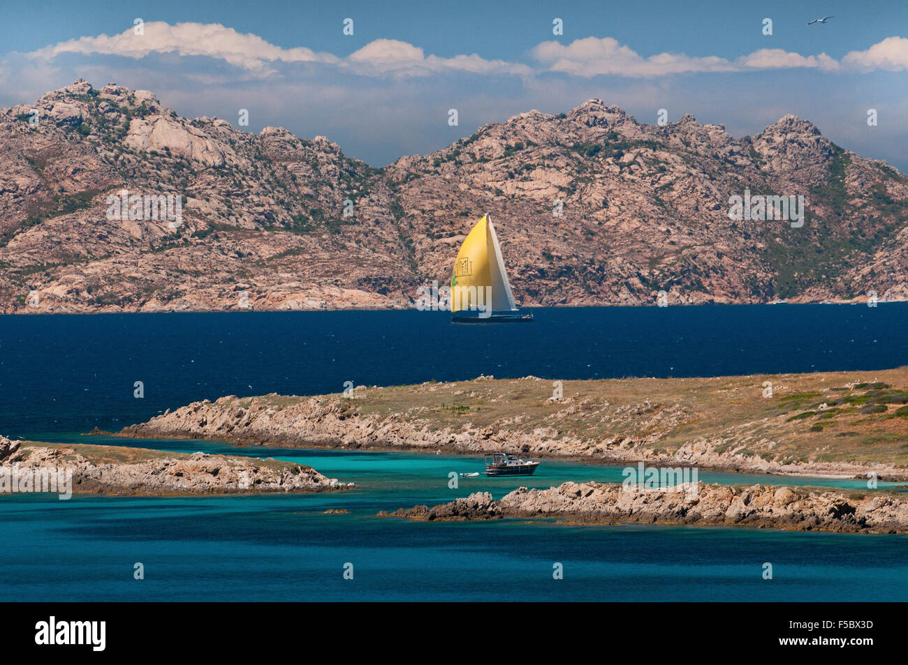 Caprera island,Sardinia, Italy, 5/2015. Yellow sail luxury yacht navigate along the coast of La Maddalena archipelago. Stock Photo