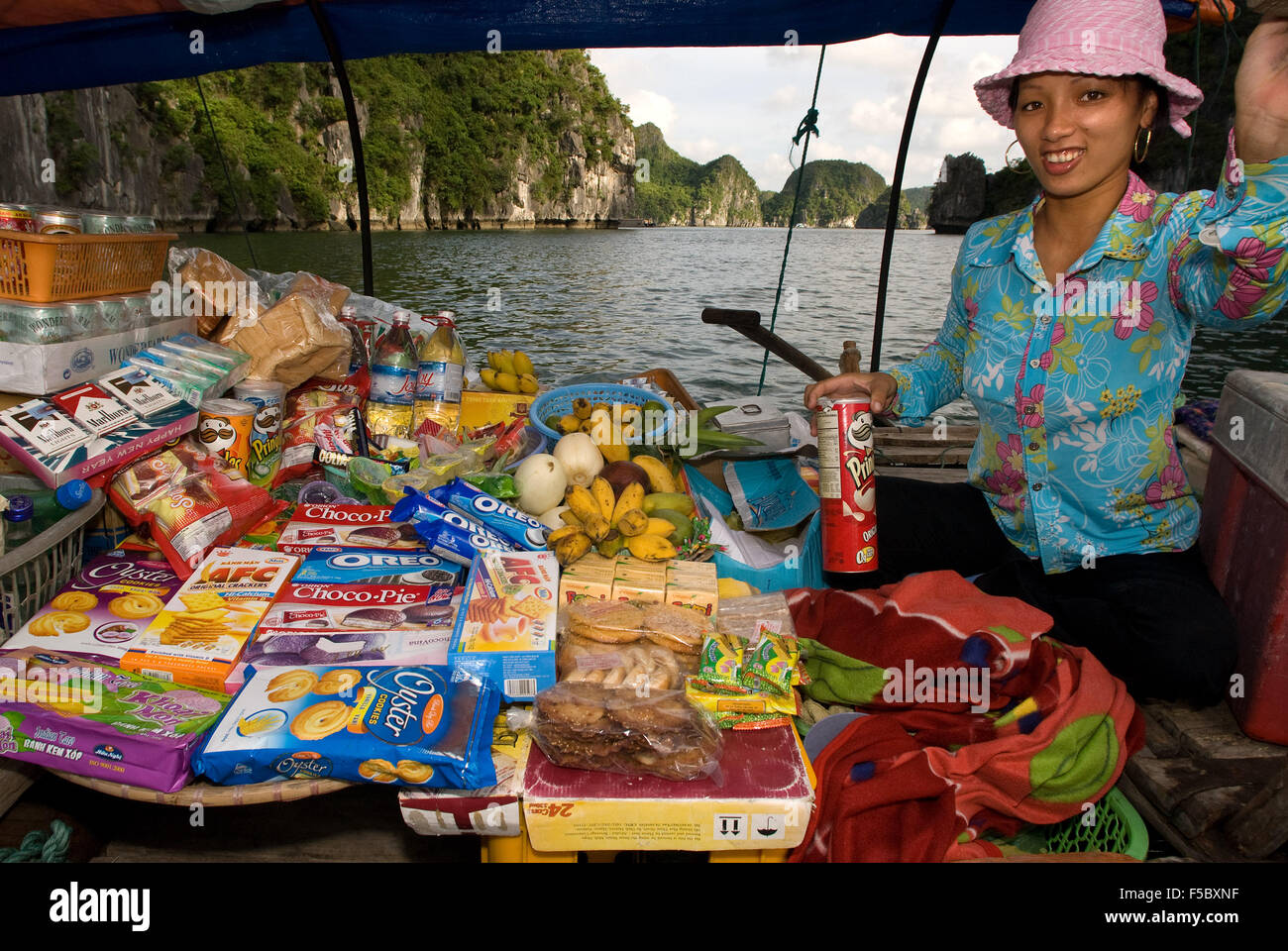 Boat woman vendor in Halong Bay, Vietnam.  Drink snack hat vendor rowing boat Halong Bay Vietnam. Stock Photo