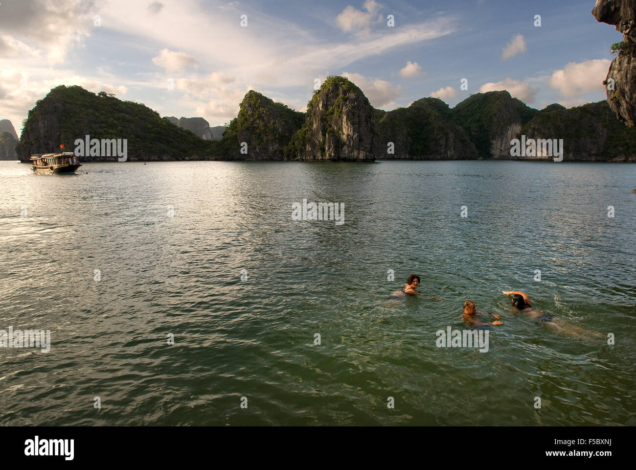 People swmming in secluded beach in isolated island in Ha Long Bay, Vietnam. Quiet tropical beach, Cat Ba National Park, Ha long Stock Photo