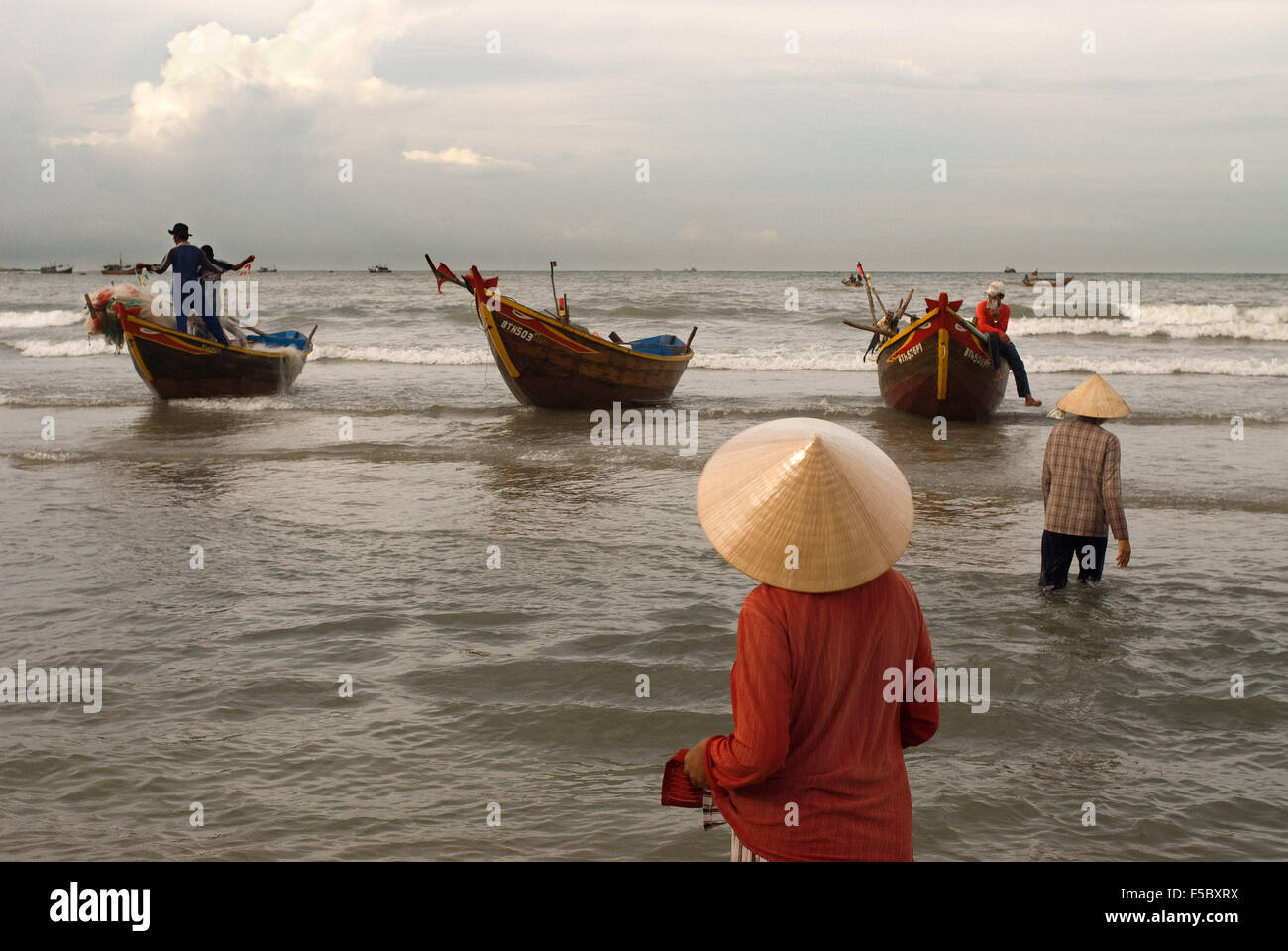 Lady awaiting the landing of the catch, Mui Ne fishing village, Bình Thuận Province, Vietnam Stock Photo