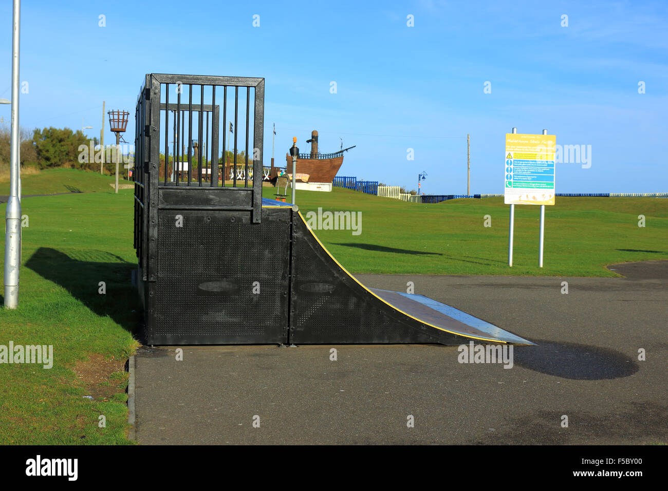 Skateboard ramps in Maplethorpe with a play area pirate ship in the background Stock Photo