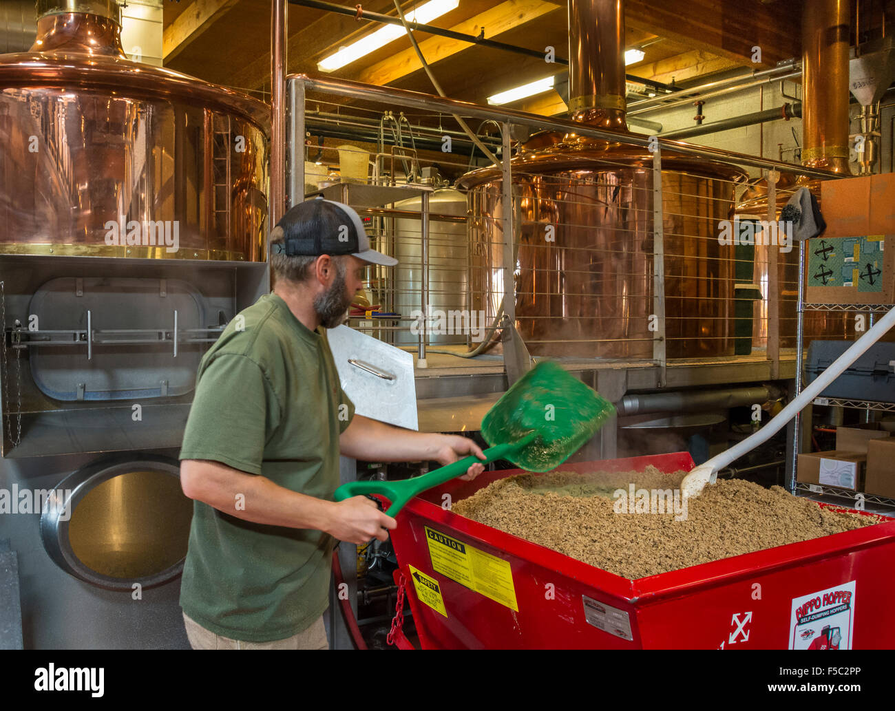 Head brewer Cam O'Connor removes trub from a fermenting tank at Crux Fermentation Project microbrewery and brewpub, Bend, Oregon Stock Photo