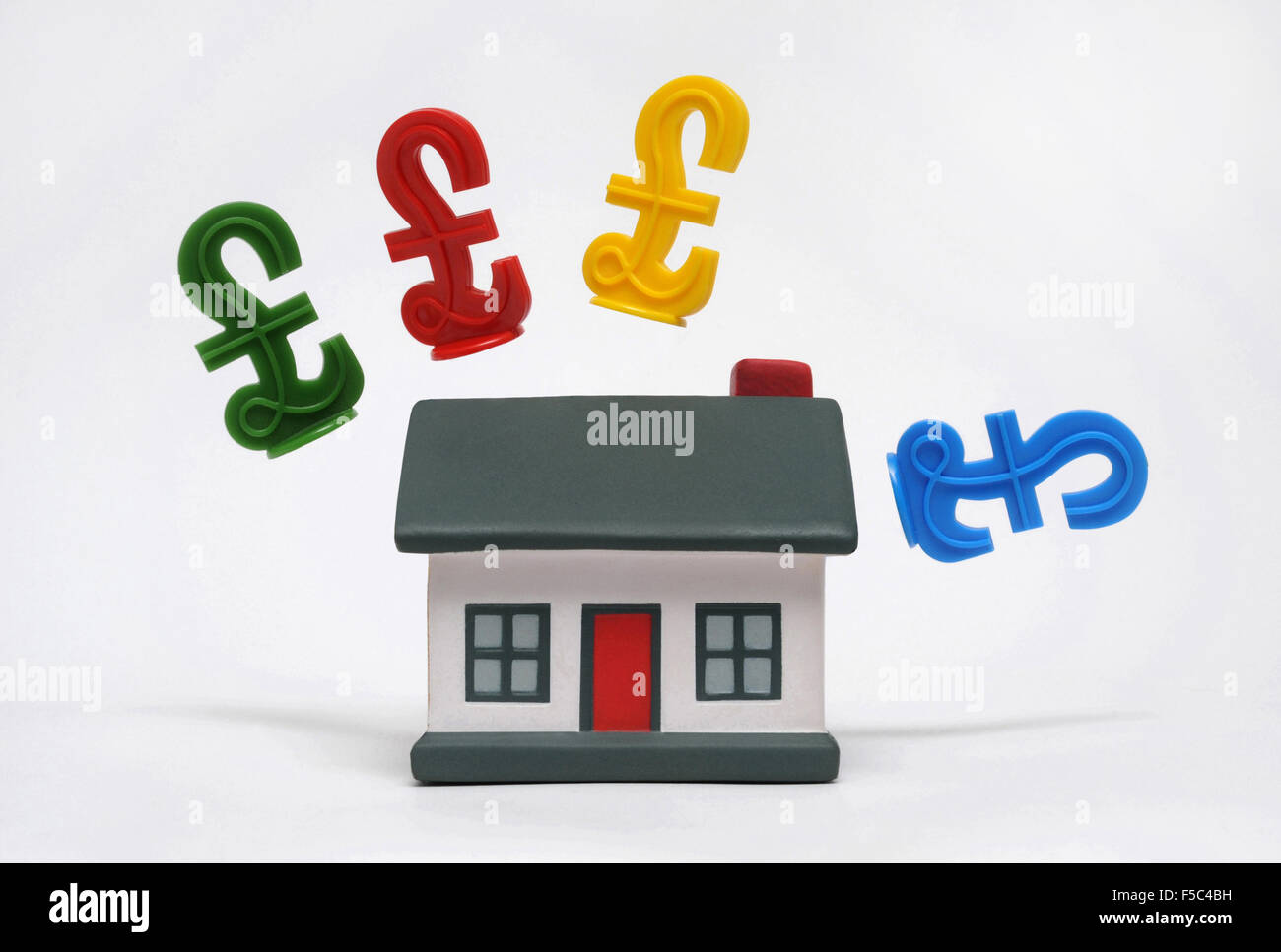 MODEL HOUSE WITH POUND SIGNS RE FIRST TIME BUYERS HOUSING MARKET PROPERTY LADDER PRICES INCOMES WAGES HOUSEHOLD BUDGETS HOMES UK Stock Photo