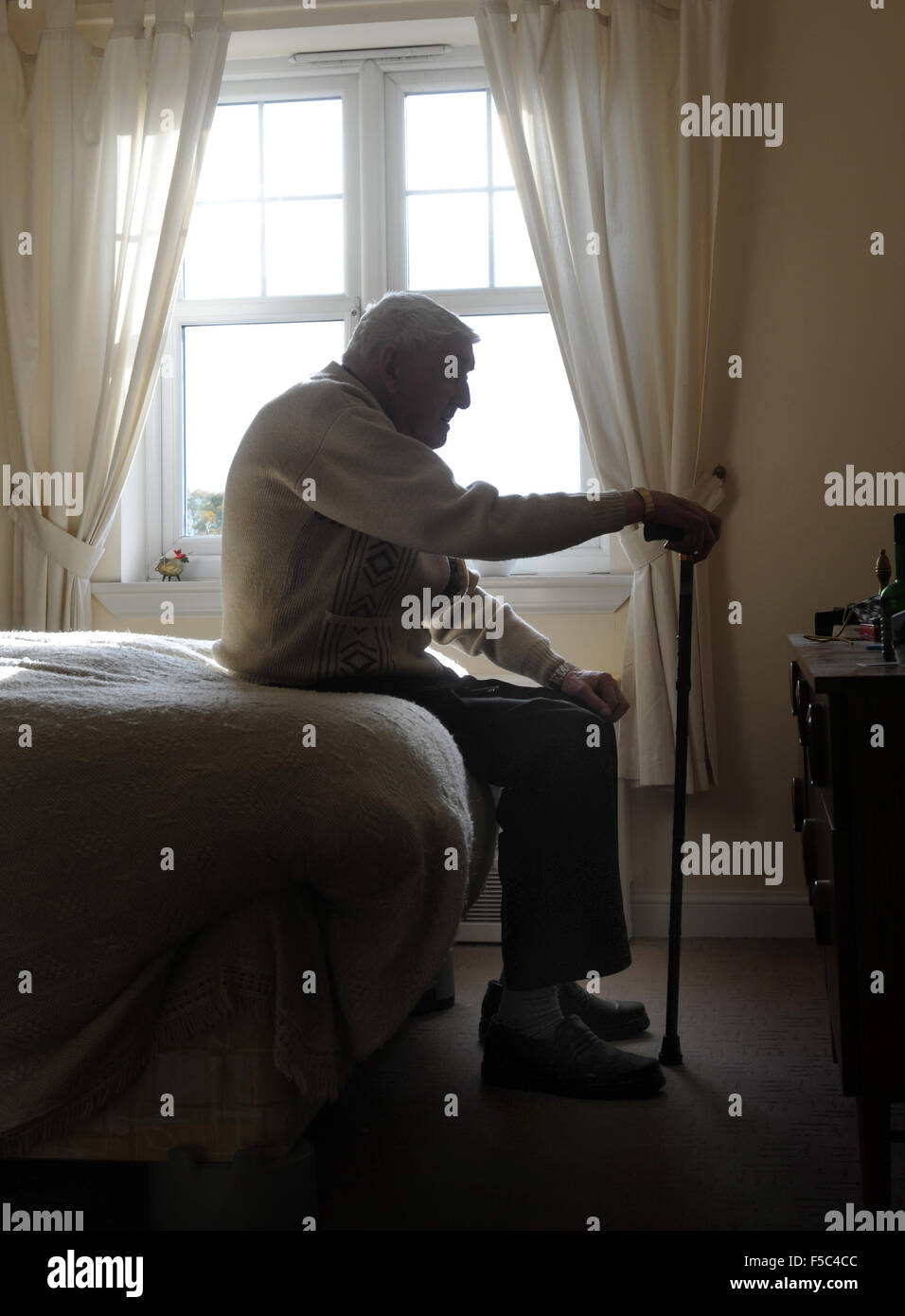 ELDERLY MAN WITH WALKING STICK RE OLD AGE LONELINESS PENSIONERS RETIREMENT CARE WORKERS HOME PEOPLES DEPRESSION MEN PENSION UK Stock Photo