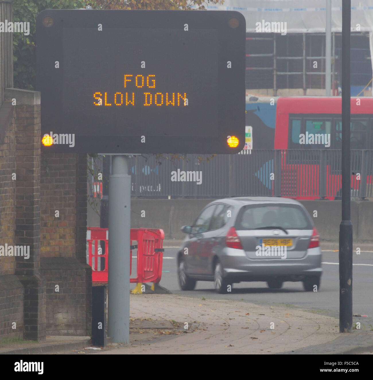 An illuminated motorway matrix sign which reads 'FOG SLOW DOWN' on the A12, East London. Stock Photo