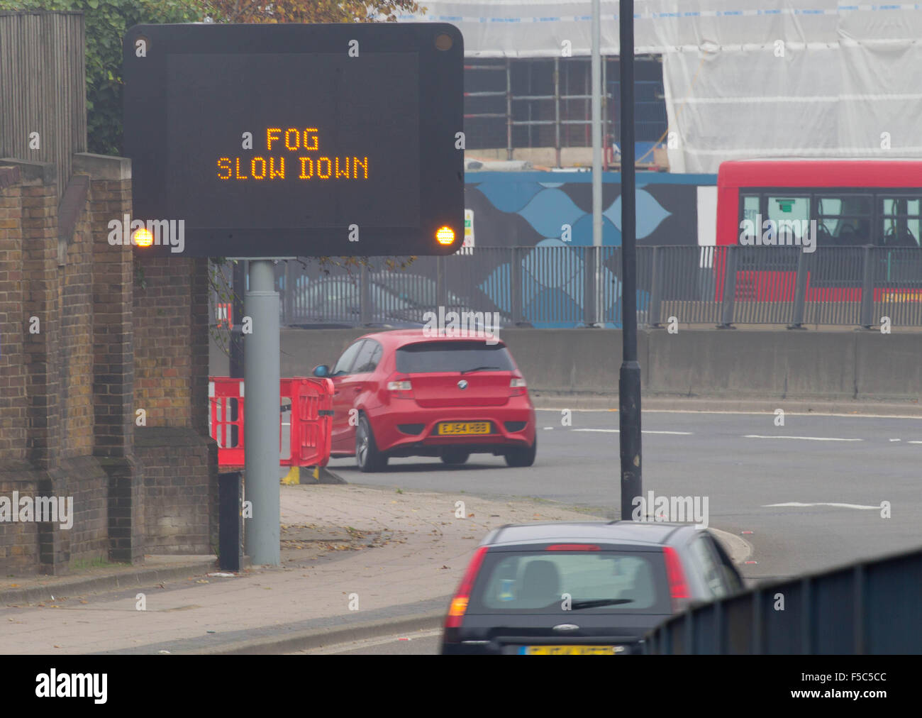 An illuminated motorway matrix sign which reads 'FOG SLOW DOWN' on the A12, East London. Stock Photo