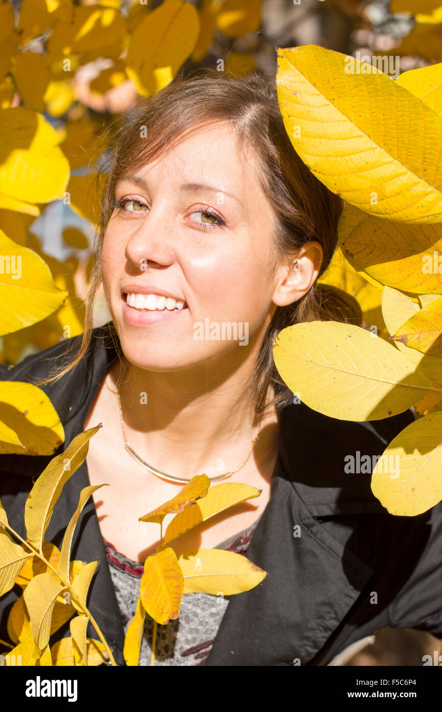 Portrait of a happy brunette girl among yellow autumn leaves Stock Photo
