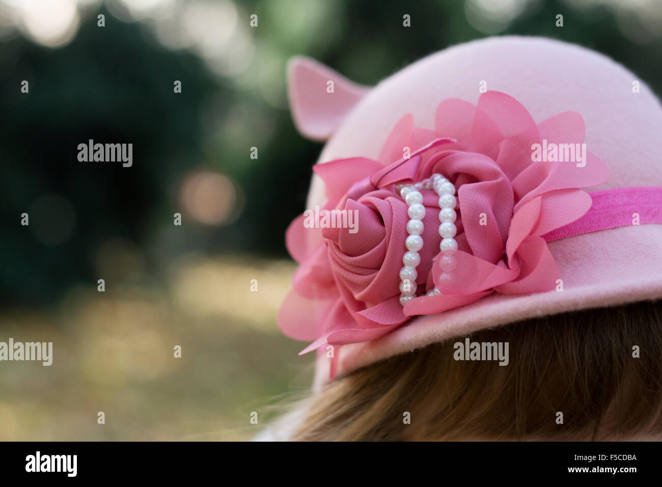 Beautiful pink headband with rose and pearls on hat for little fashionable girls Stock Photo