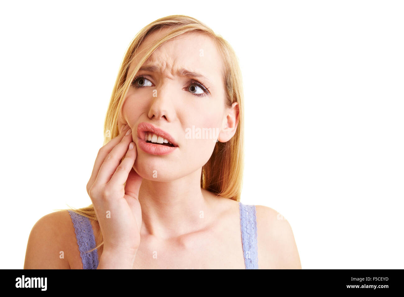 Young blonde woman with toothache holding her cheek Stock Photo