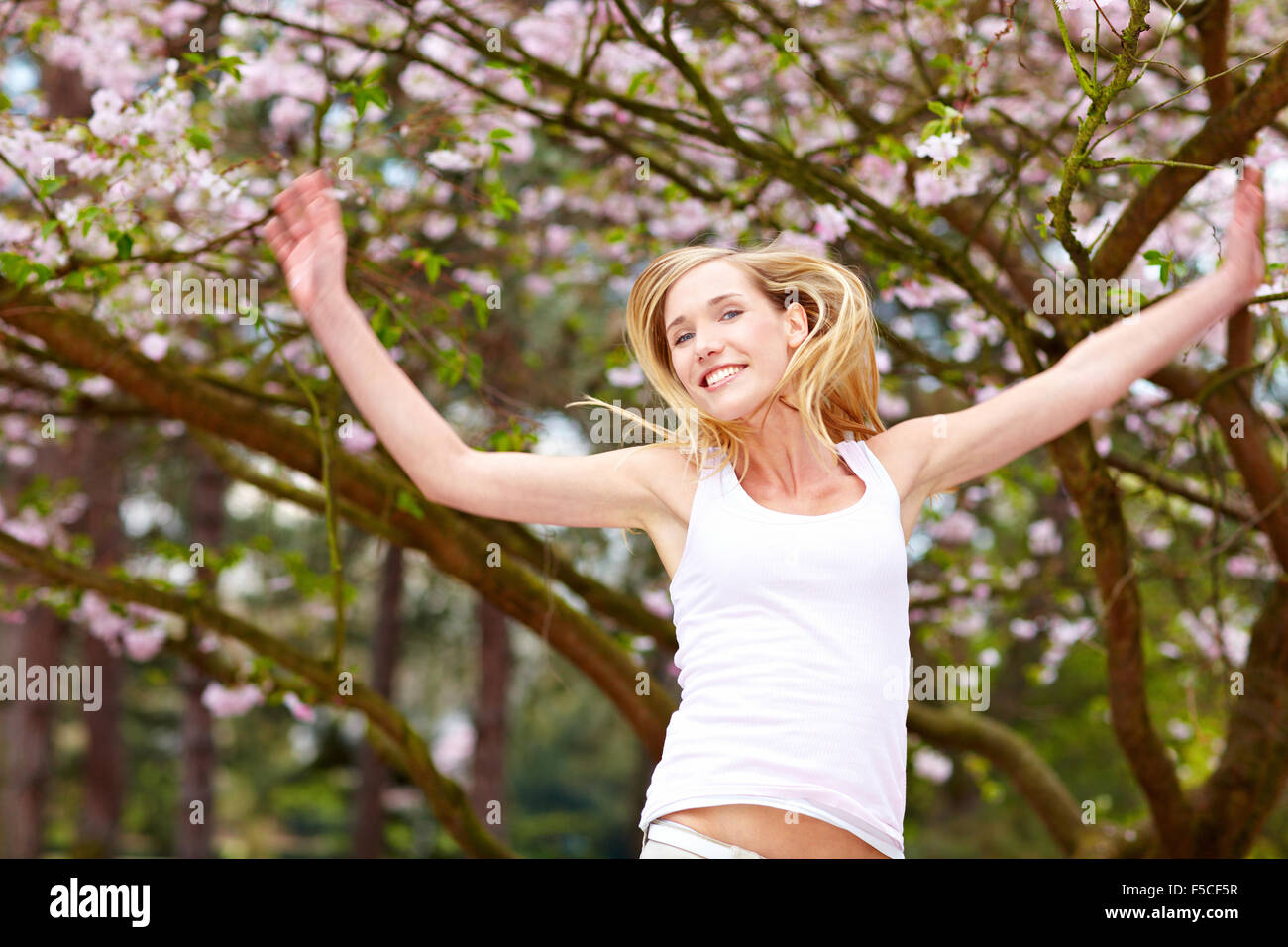 Young woman under a blooming cherry tree Stock Photo - Alamy