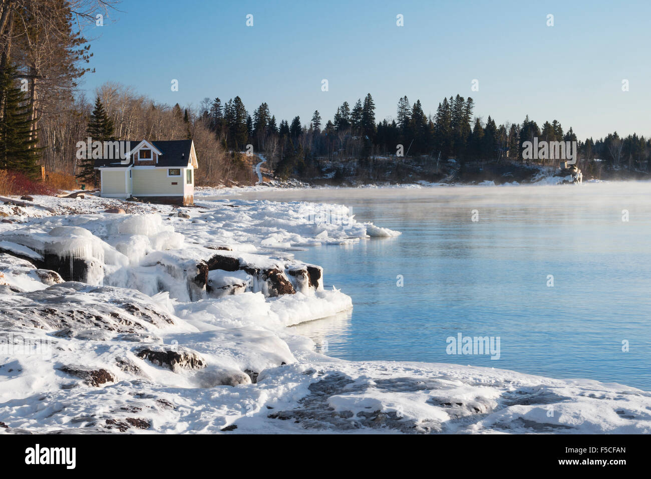 Yellow cabin perched on frozen shore of Lake Superior in northern Minnesota, Two Harbors, MN, USA Stock Photo