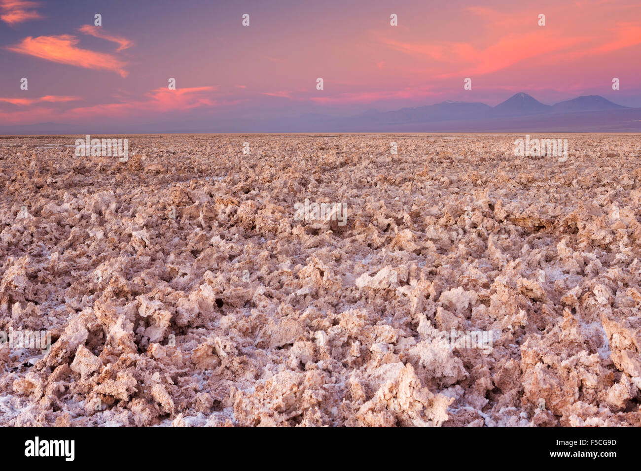 A rough salt flat with volcanoes in the distance. Photographed at the Salar de Atacama in the Atacama Desert, northern Chile, at Stock Photo