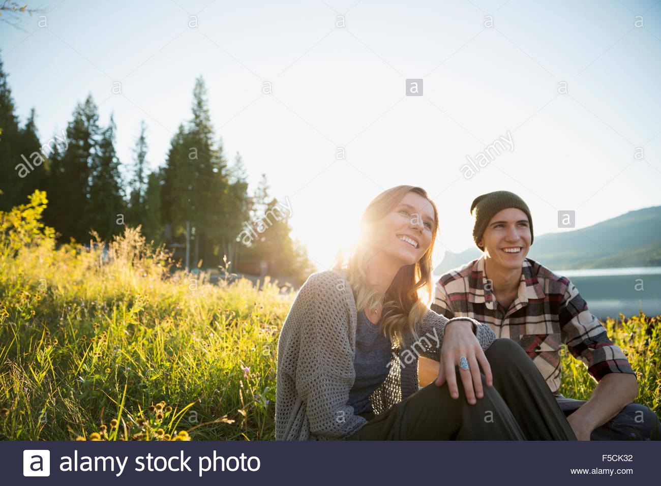 Young couple relaxing in sunny grass Stock Photo - Alamy