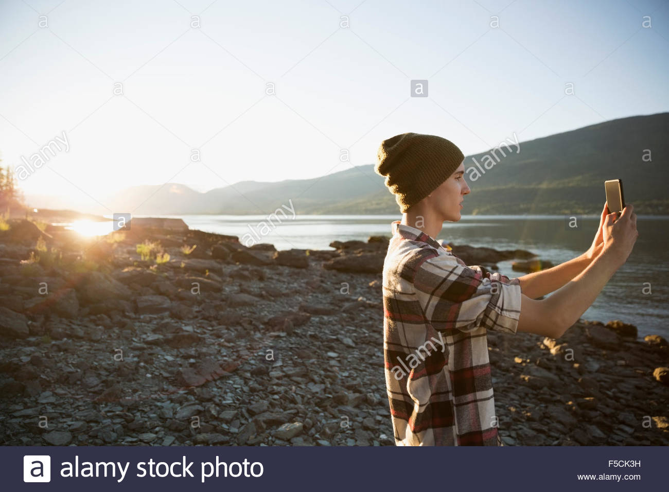Young man photographing lake Stock Photo