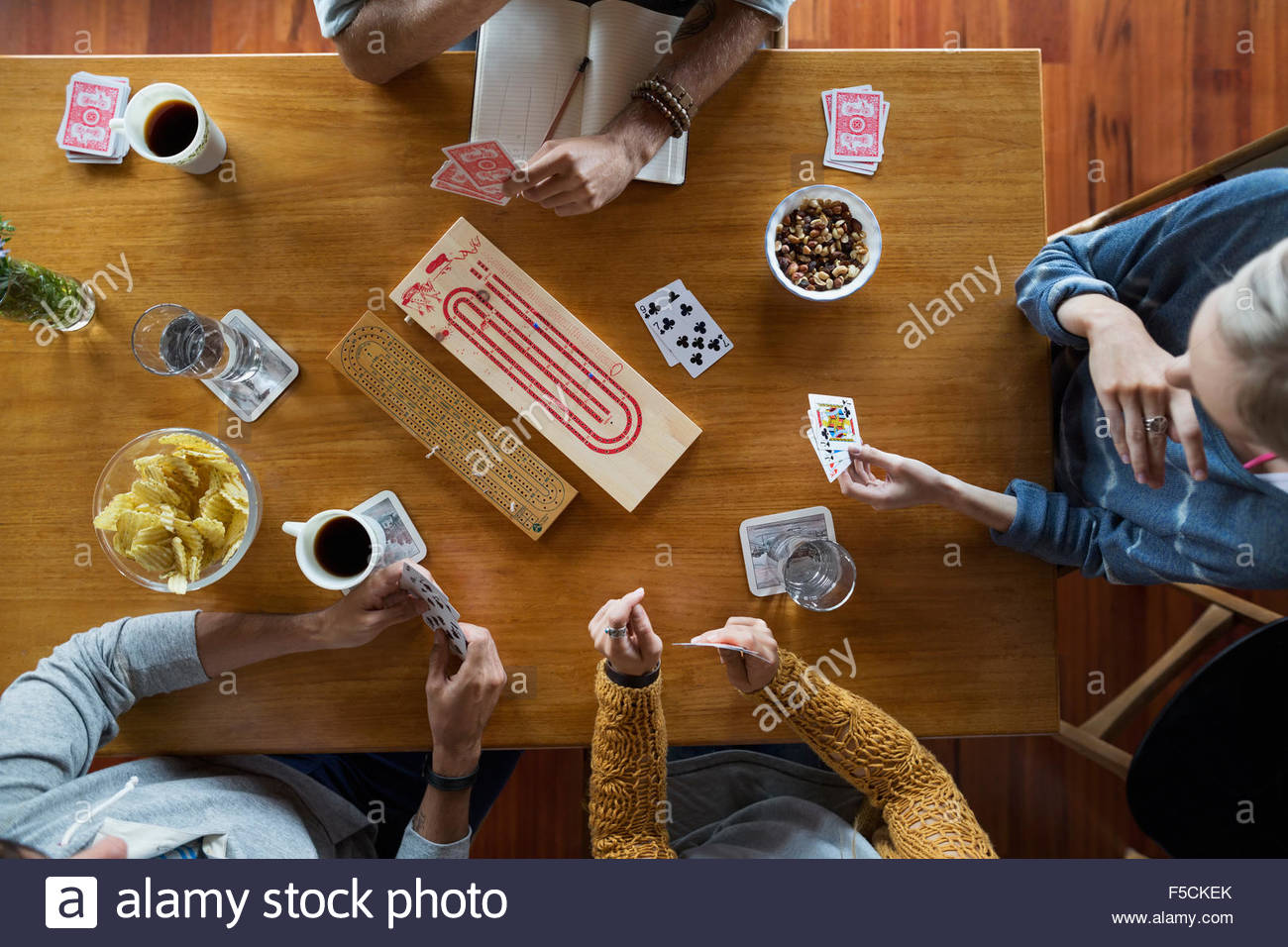 Overhead view of young friends playing cribbage table Stock Photo Alamy