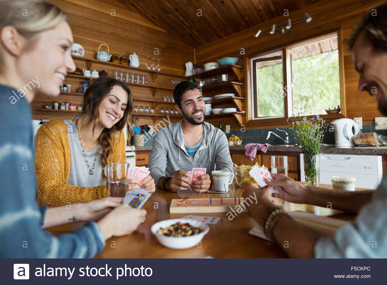 Young friends playing cribbage at cabin table Stock Photo Alamy