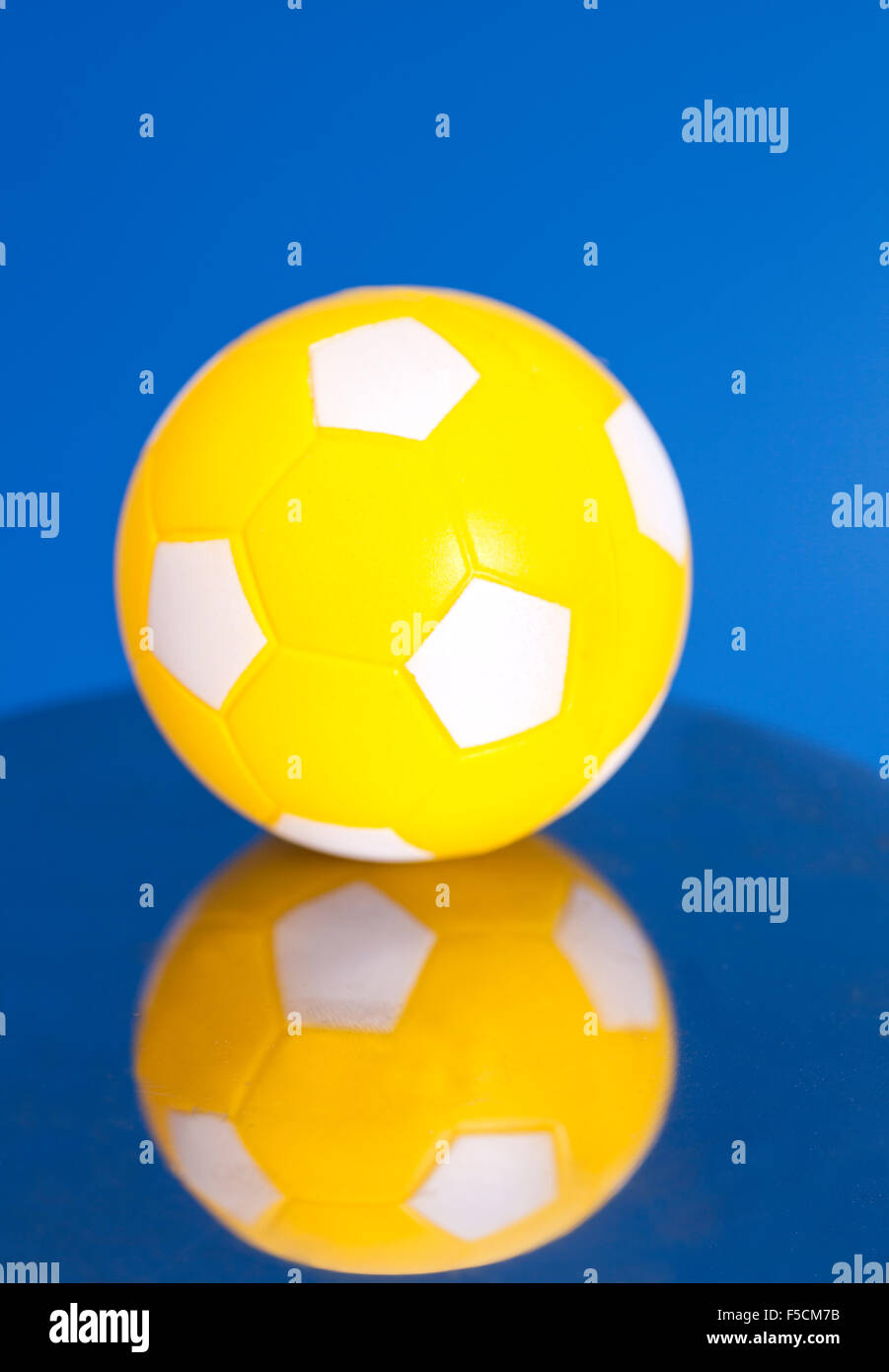 Yellow Soccer Ball with reflection on blue background Stock Photo - Alamy