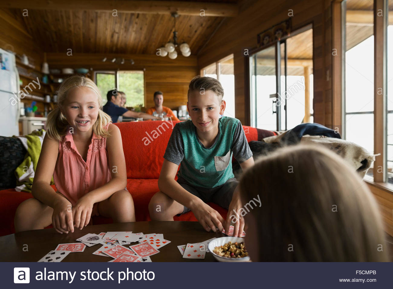 Cousins playing cards in cabin Stock Photo