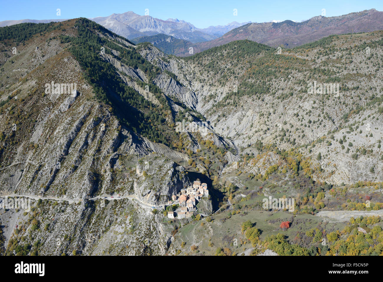 AERIAL VIEW. Small village curiously perched on a rocky outcrop in a remote area. Auvare, Alpes-Maritimes, French Riviera's backcountry, France. Stock Photo