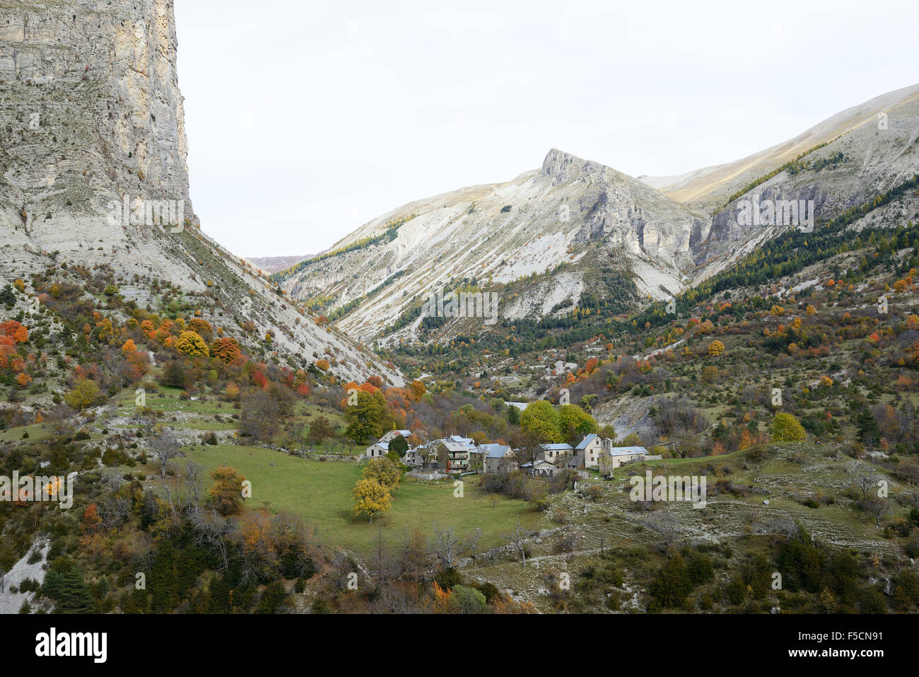 Abandoned hamlet in a remote alpine valley at the foot of a massive cliff. Aurent, Coulomp Valley, Alpes de Haute-Provence, France. Stock Photo