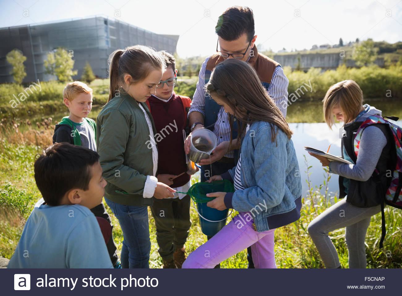 Science teacher and students conducting experiment field trip Stock