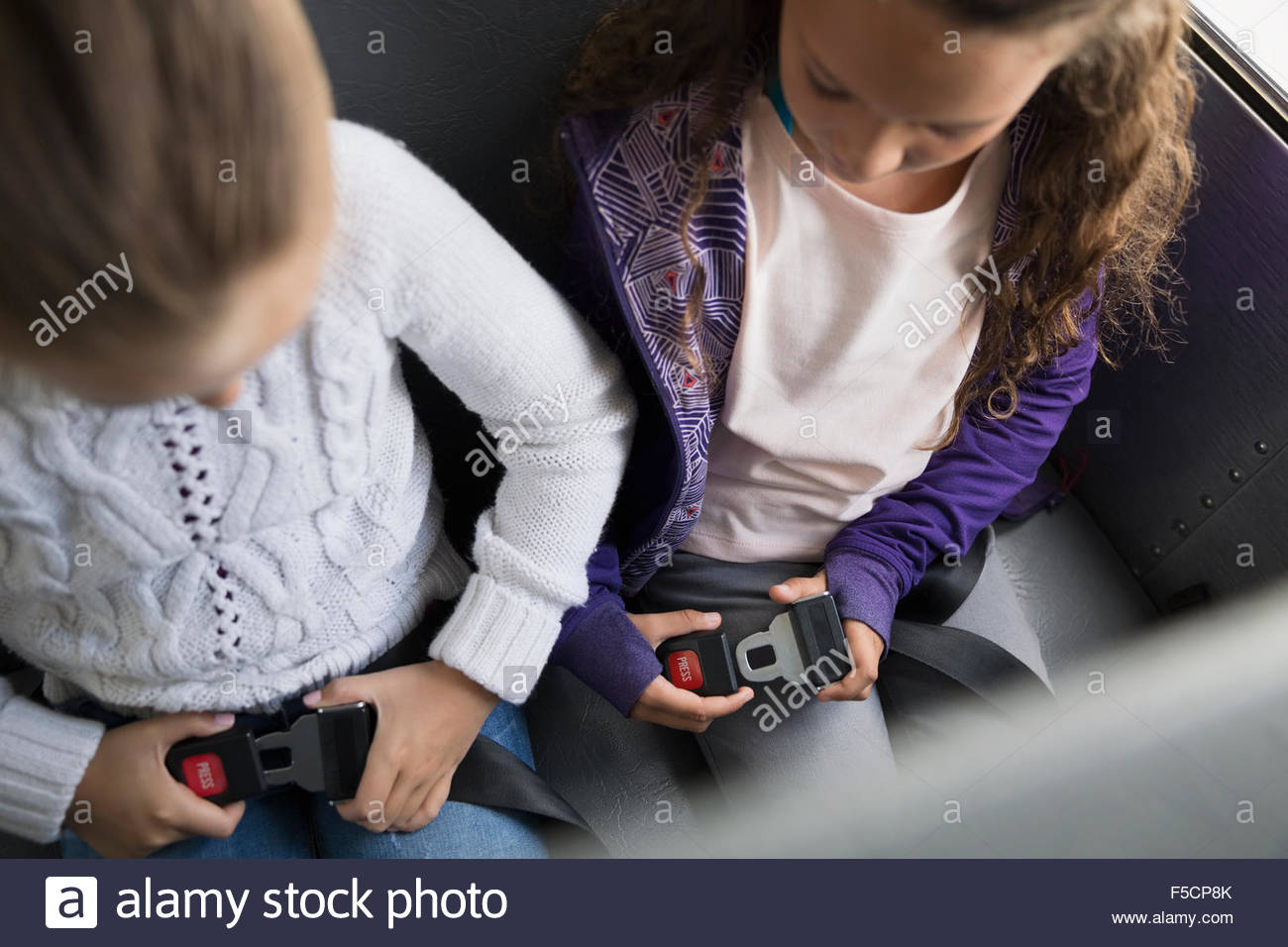 Schoolgirls fastening seat belts on school bus Stock Photo Alamy