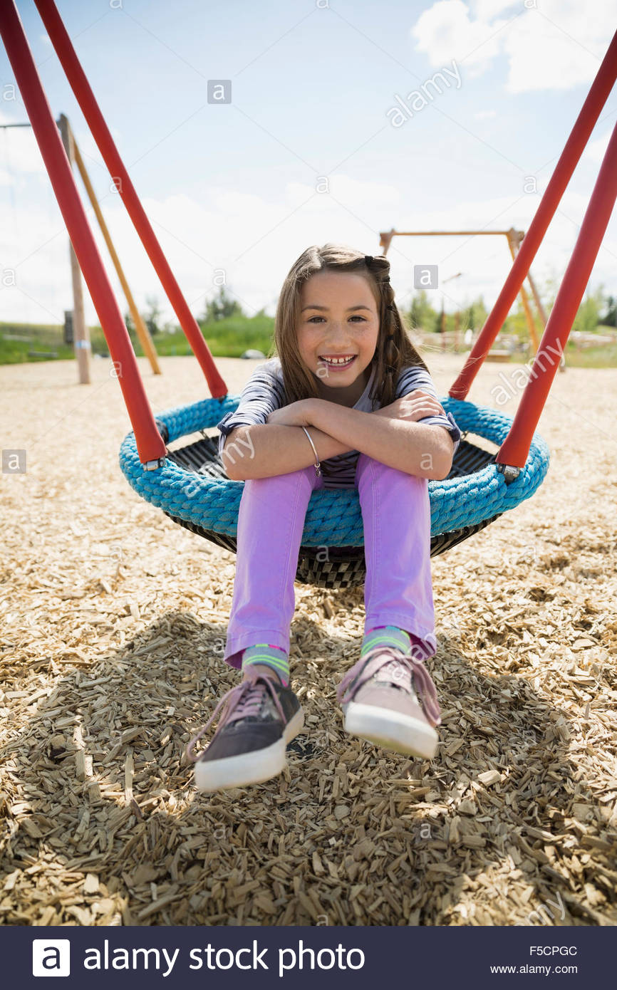 Portrait smiling girl sitting in swing sunny playground Stock Photo - Alamy