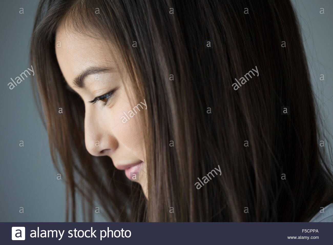 Close up profile pensive brunette woman looking down Stock Photo