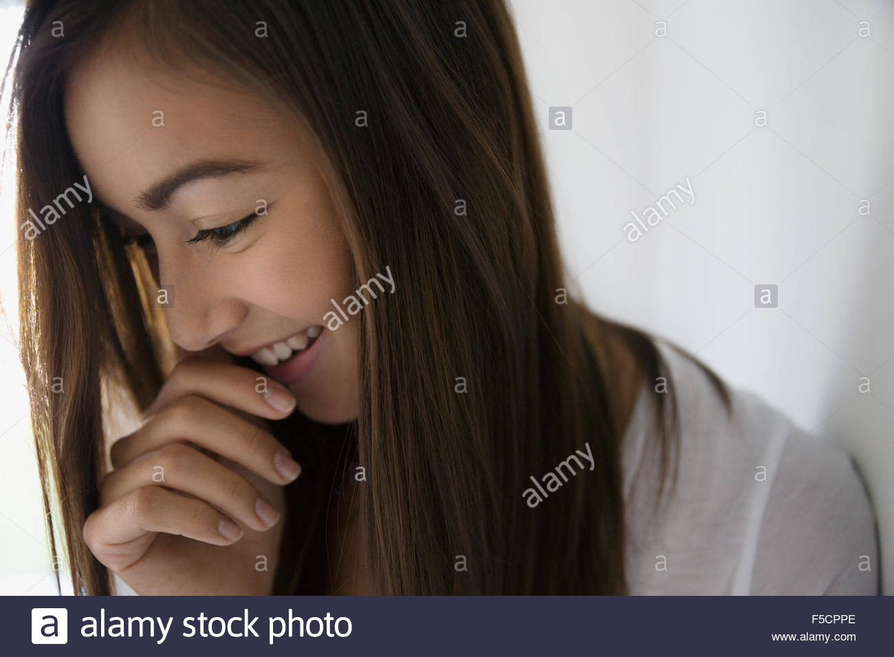 Close up smiling brunette young woman looking down Stock Photo