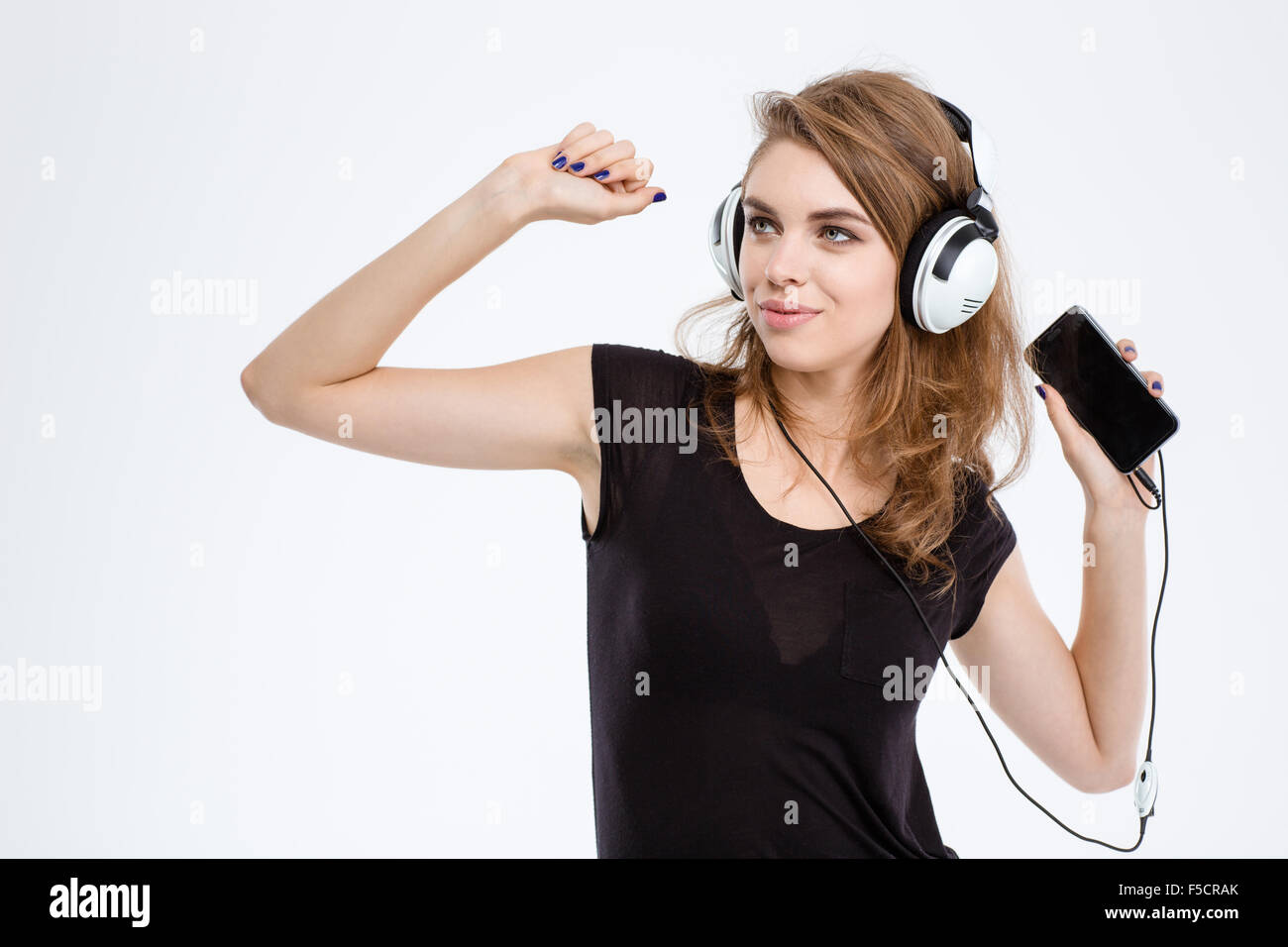 Portrait of a smiling woman listening the music in headphones on ...