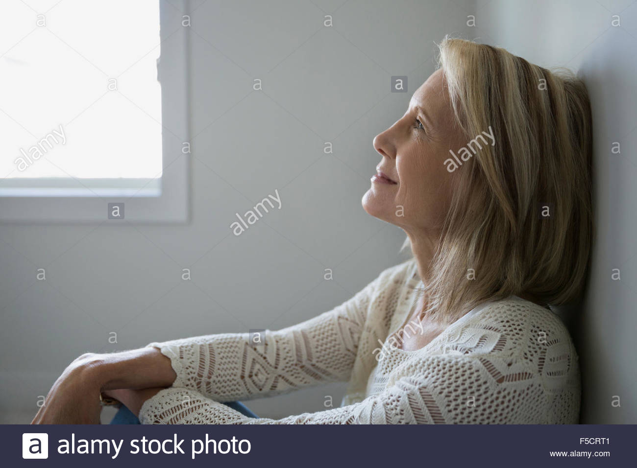 Profile pensive senior woman looking up Stock Photo