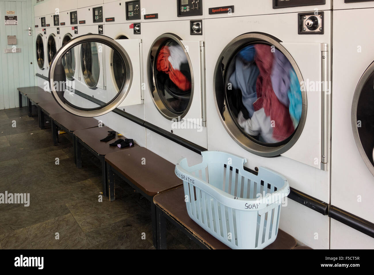 Interior of laundrette (tumble drier in action), UK Stock Photo