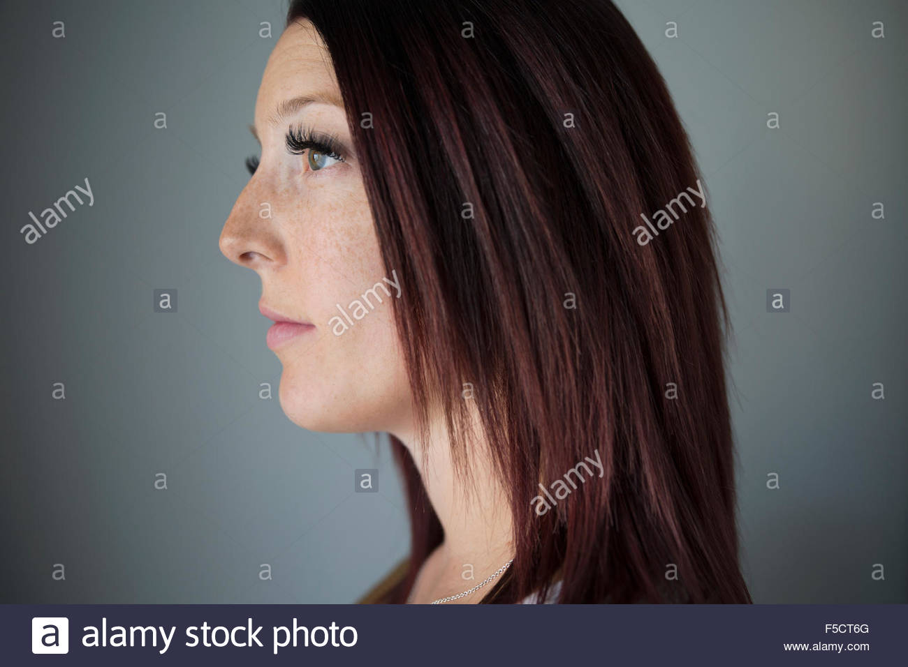 Close up profile pensive woman with red hair Stock Photo