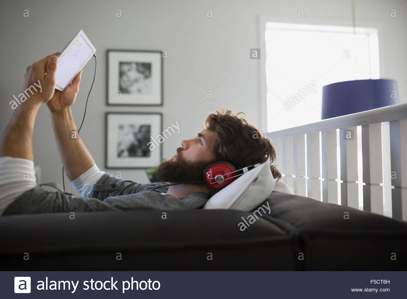 Man with digital tablet headphones listening to music Stock Photo