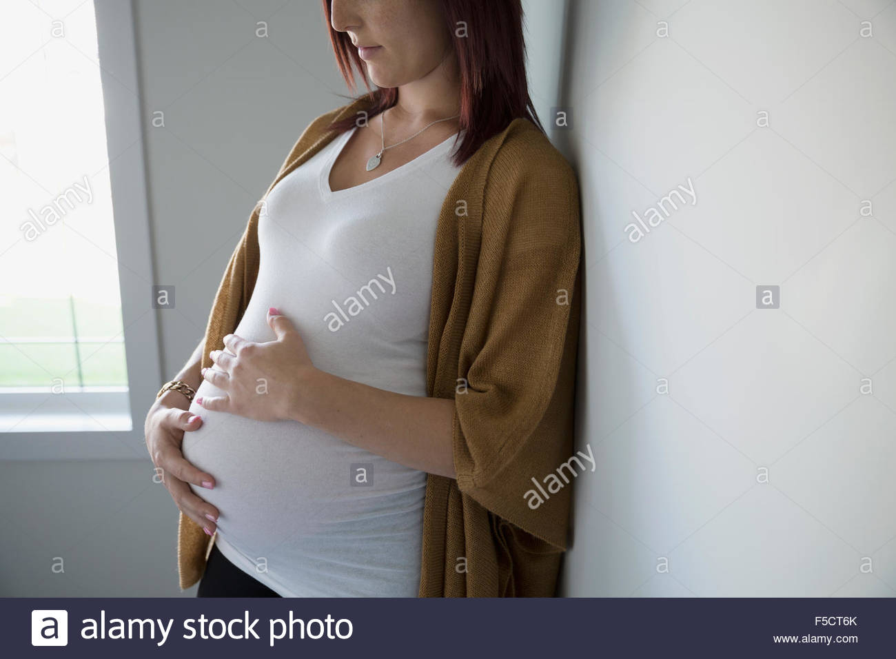 Pregnant woman holding stomach Stock Photo