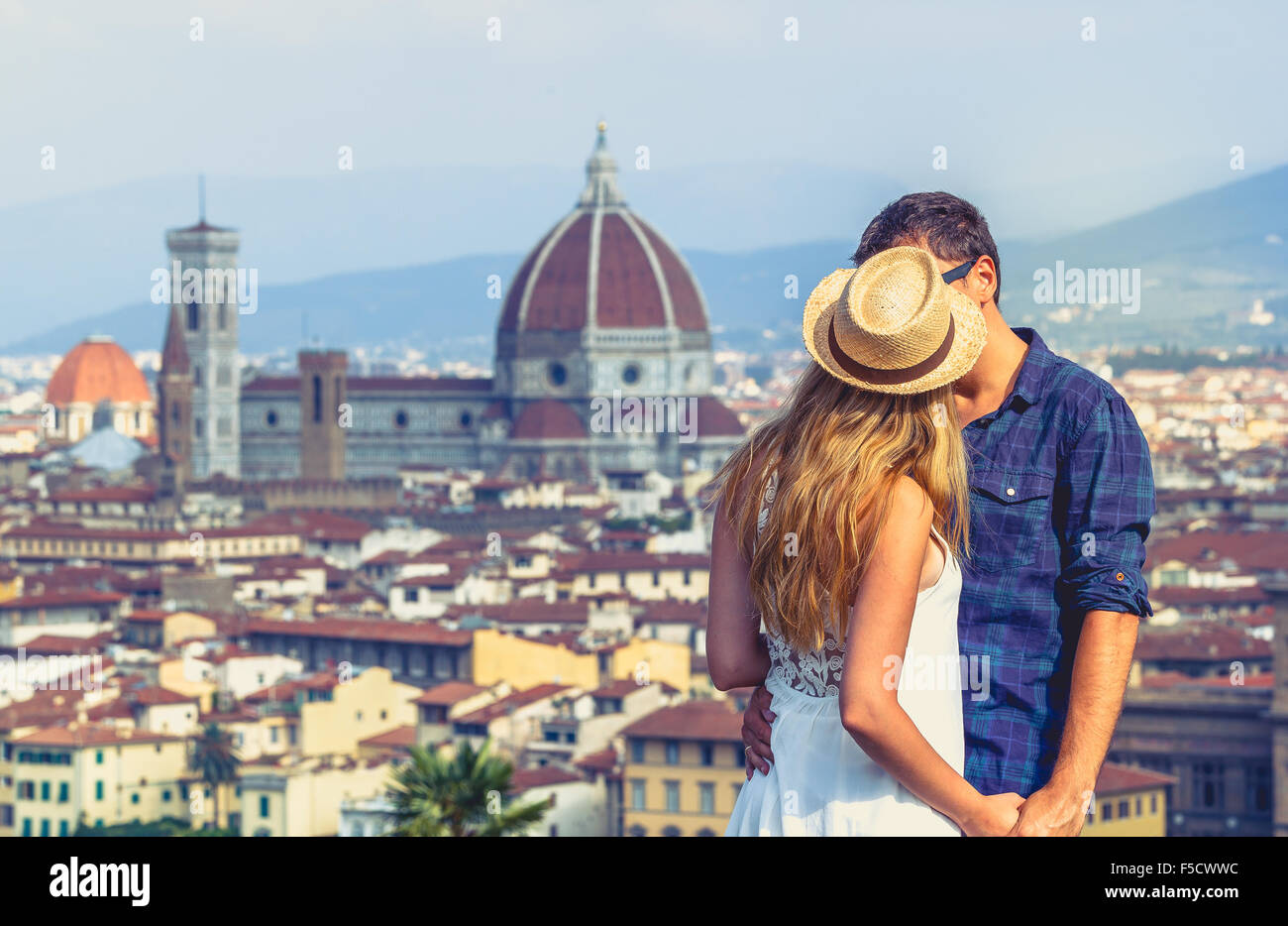 A young couple kissing with the view of Santa María del Fiore Cathedral from Piazzale Michelangelo, Florence, Tuscany, Italy. Stock Photo