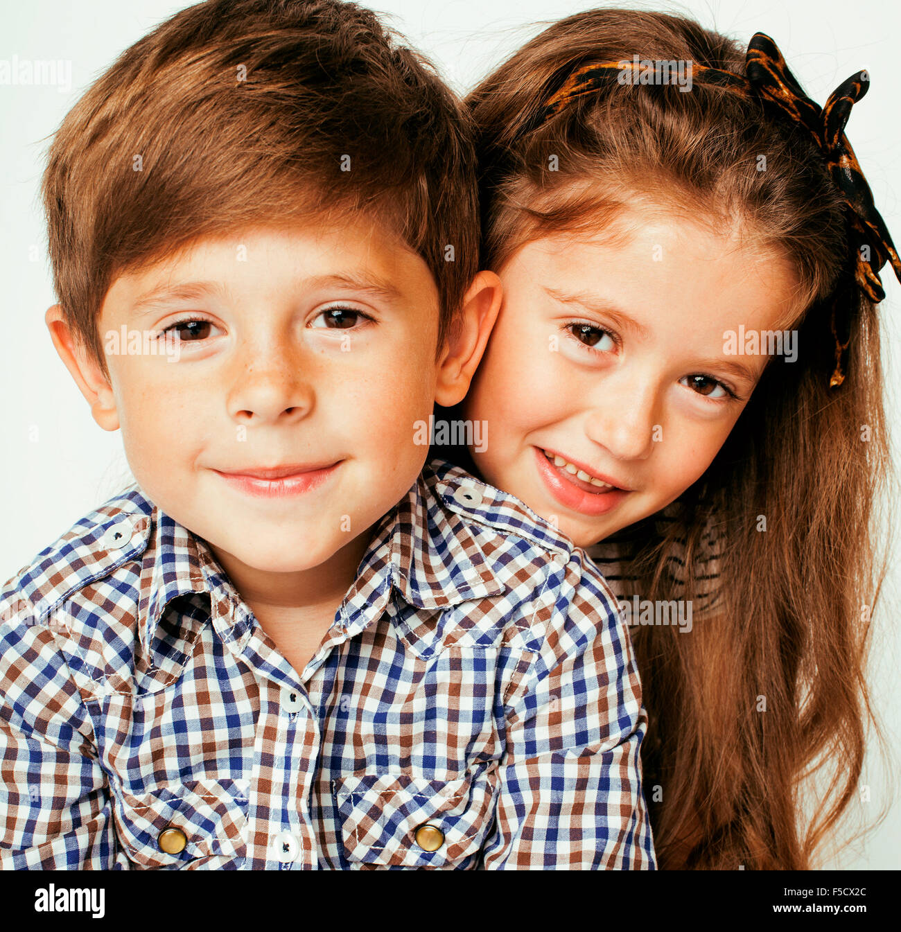 little cute boy and girl hugging playing on white background, happy family close up Stock Photo