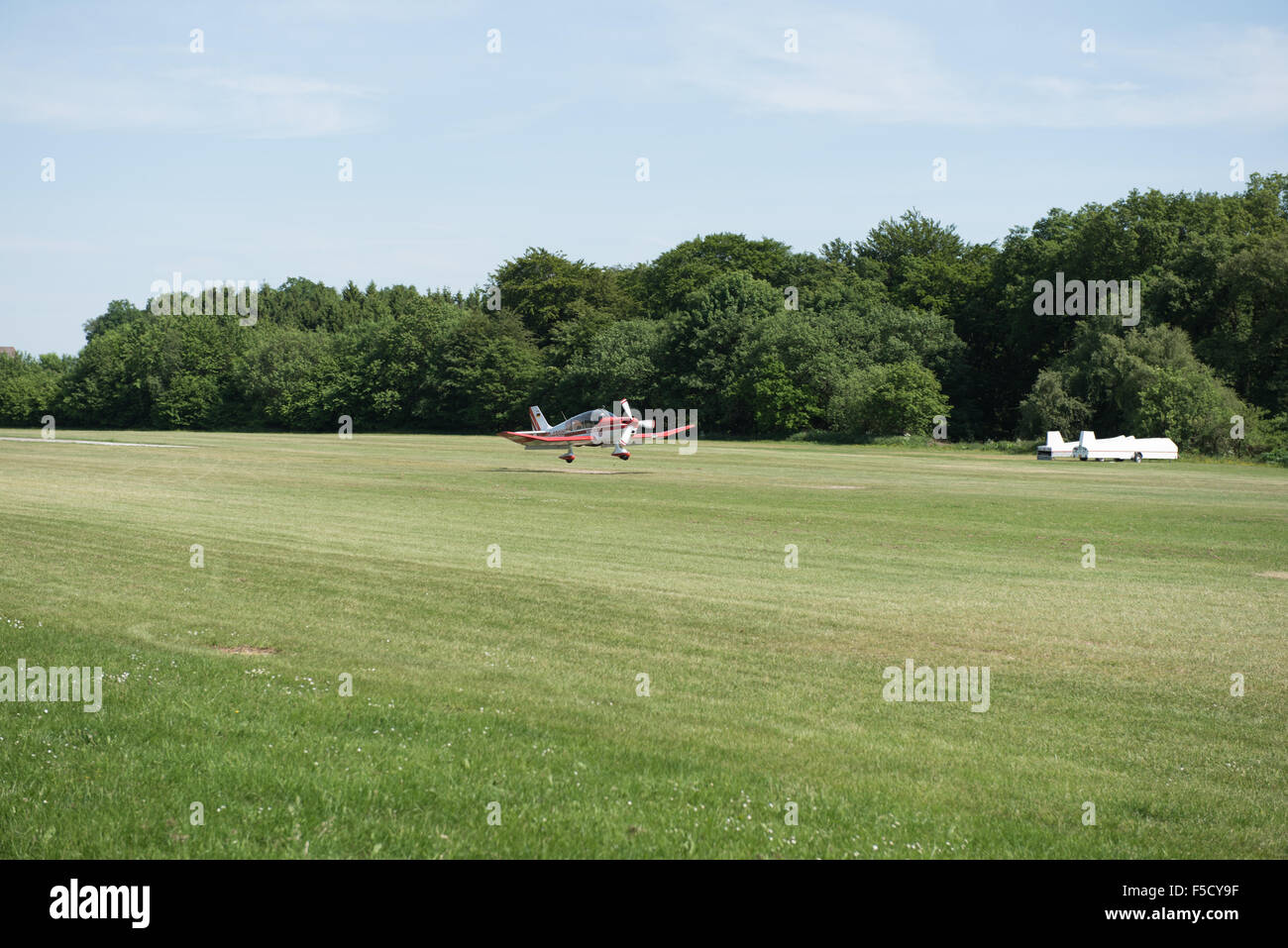 small aircraft just landing on grass Stock Photo