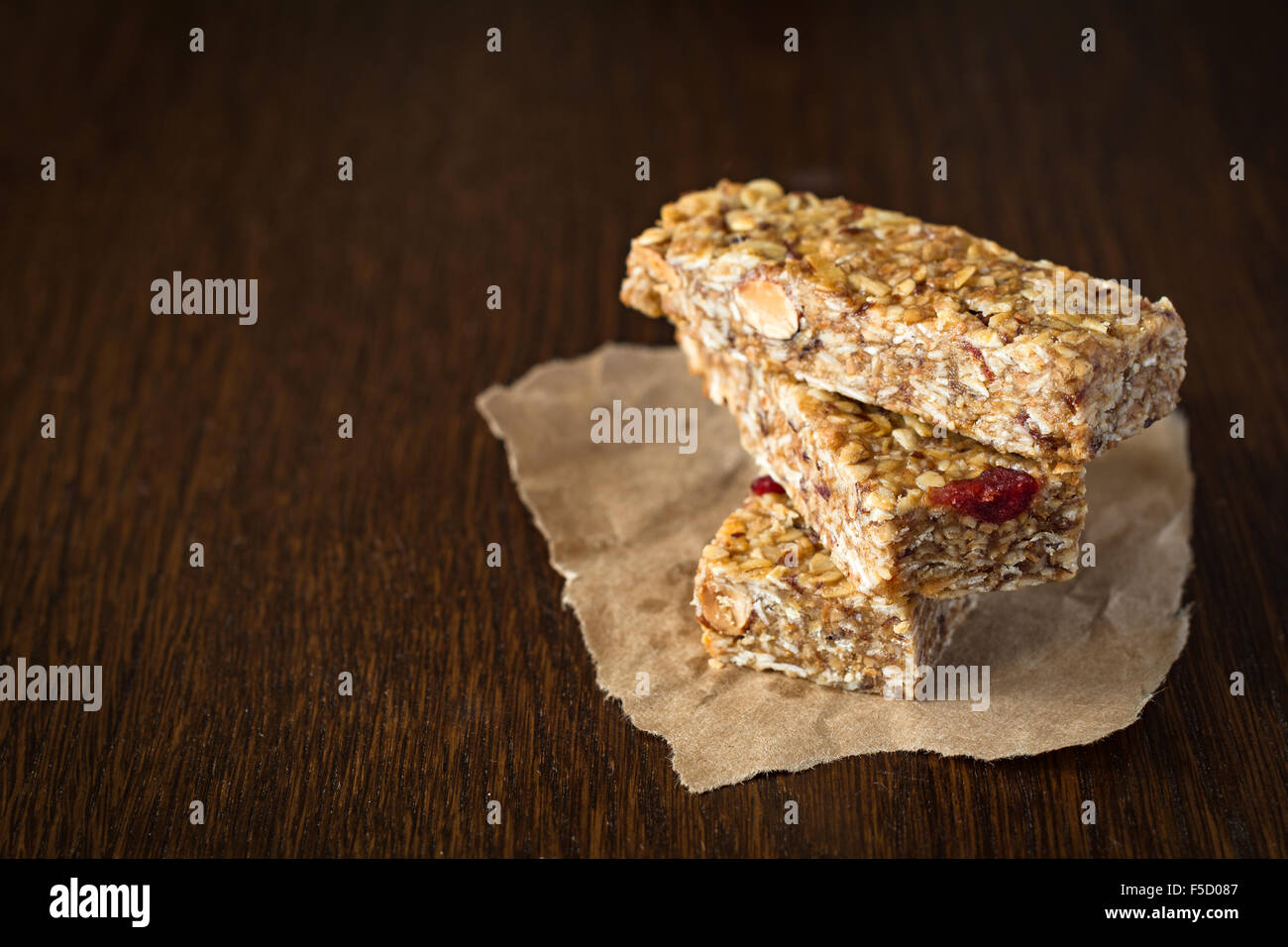 Granola bar or energy bar with oats, dates and nuts on brown wooden