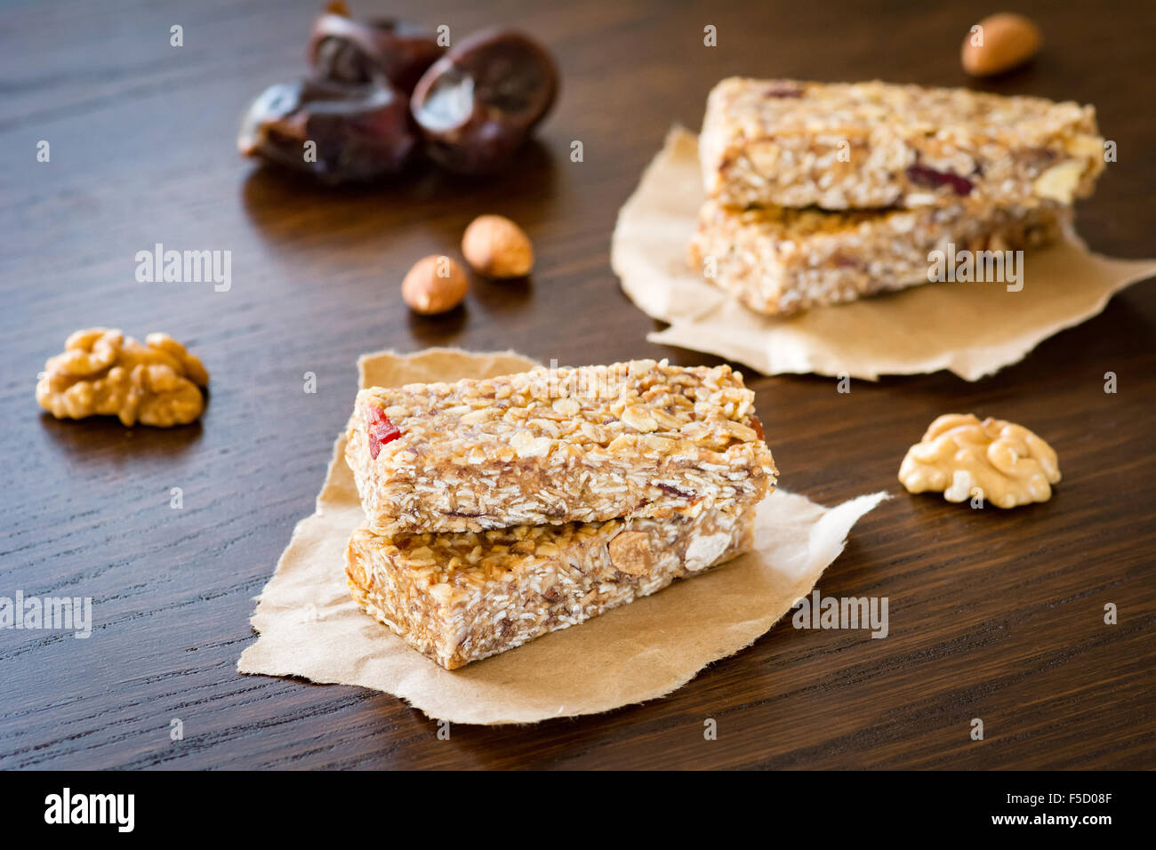 Granola bar or energy bar with oats, dates and nuts on brown wooden background. Healthy snack