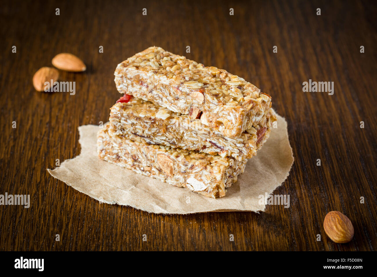 Granola bar or energy bar with oats, dates and nuts on brown wooden background. Healthy snack