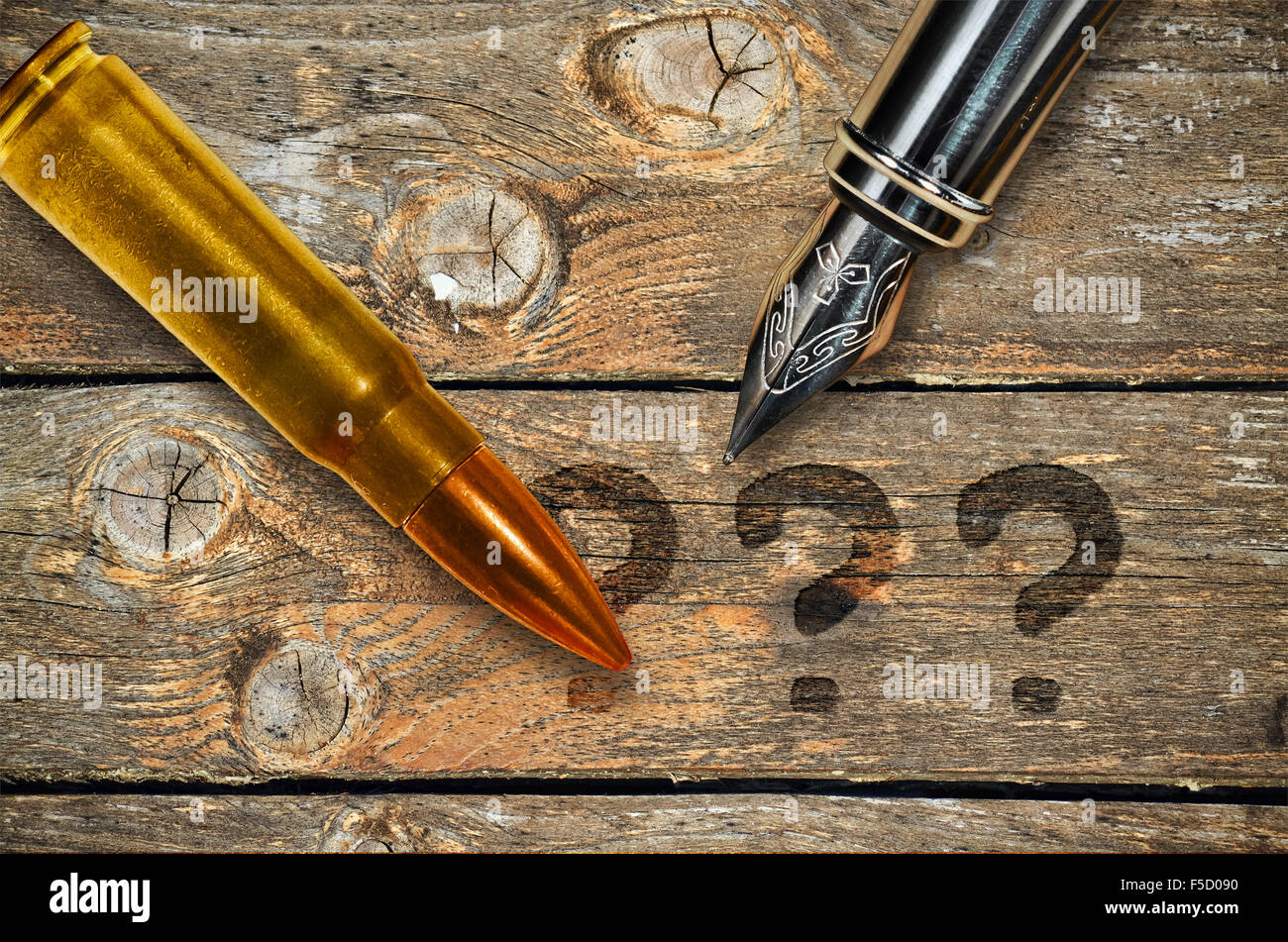 Fountain pen and bullet on wooden background and three question marks Stock Photo Alamy