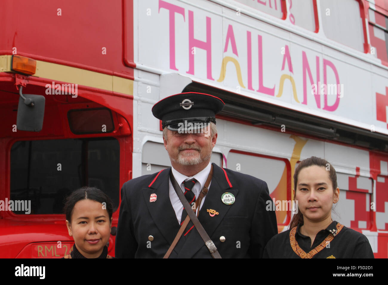 London, UK 2 November 2015.  Two ladies from Thailand Tourism and a Route master bus driver pose for photos outside the Excell Centre during the World Travel Market 2015. Credit:  david mbiyu/Alamy Live News Stock Photo