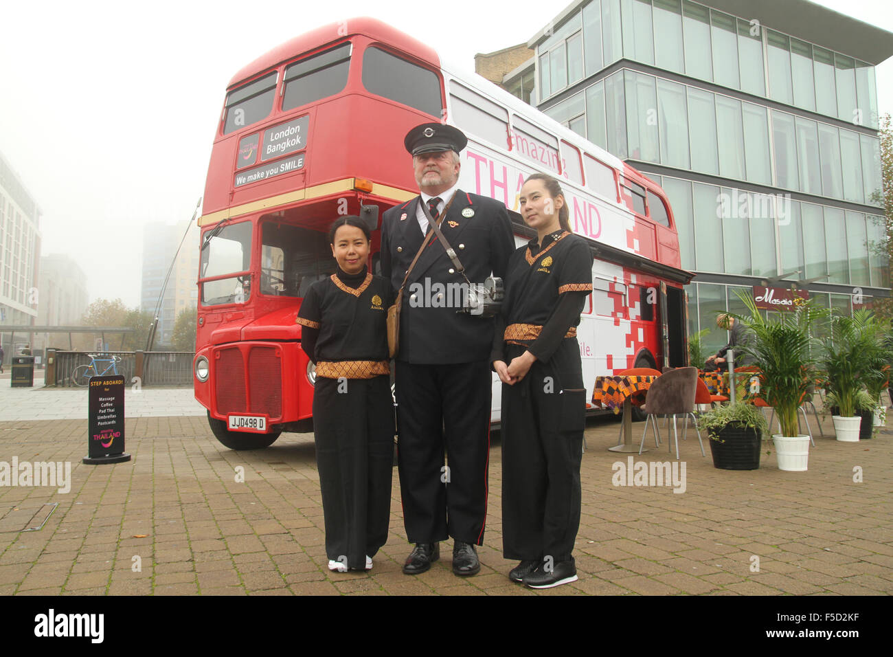 London, UK 2 November 2015.  Two ladies from Thailand Tourism and a Route master bus driver pose for photos outside the Excell Centre during the World Travel Market 2015. Credit:  david mbiyu/Alamy Live News Stock Photo