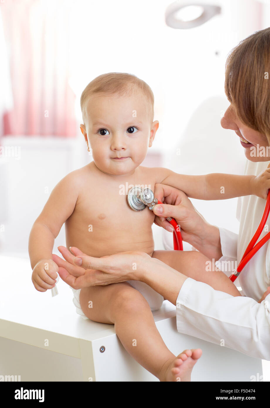 pediatrician doctor with quiet baby in medical room Stock Photo