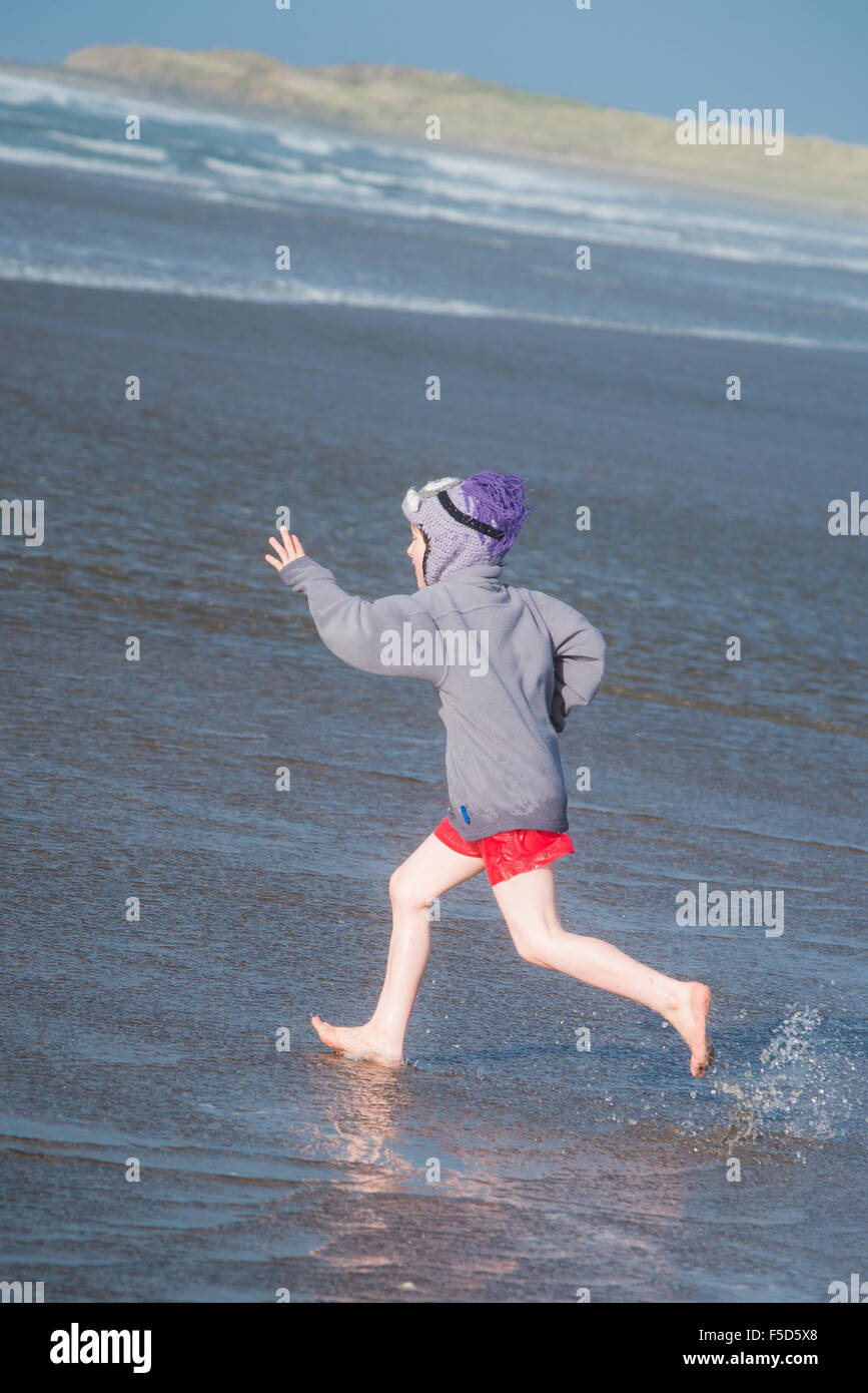 boy playing in the ocean at turnberry beach scotland Stock Photo
