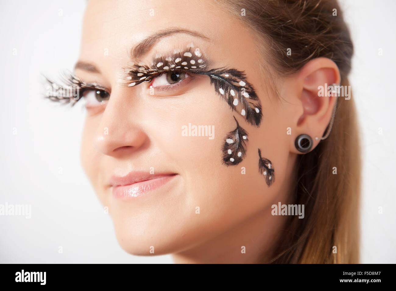Beautiful woman with long eyelashes and face-art, close-up Stock Photo