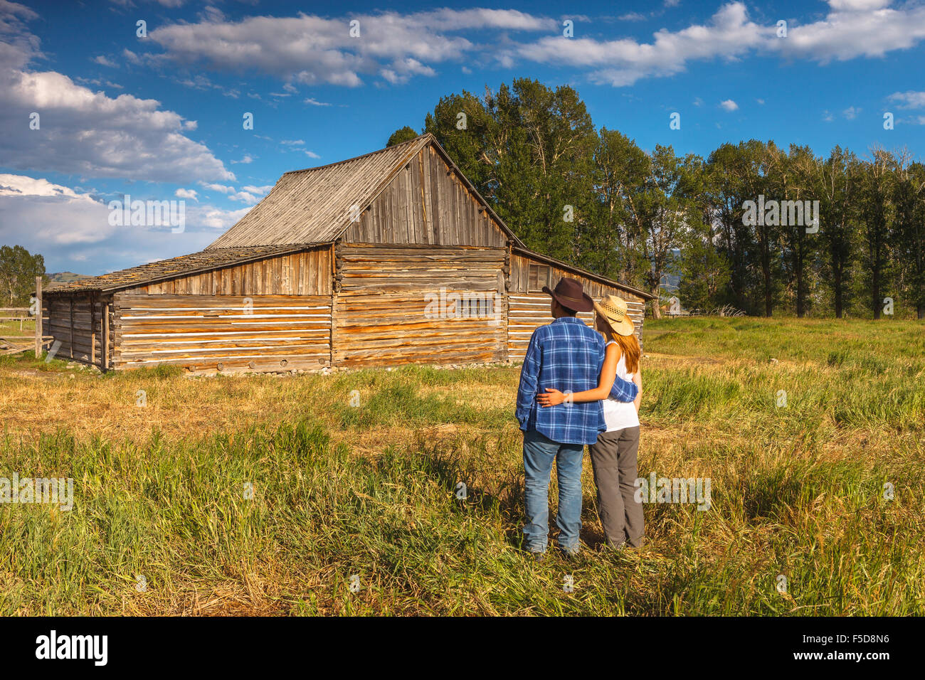 A young couple by Thomas Alma Moulton Barn, Antelope Flats, Grand Teton National Park, Wyoming, USA. Stock Photo