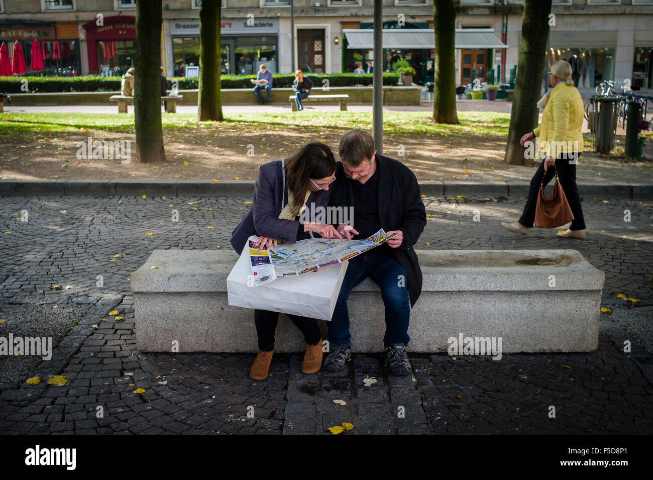 Two people sit and study a map in the precepts of Rouen Cathedral, Normandy, France. Stock Photo